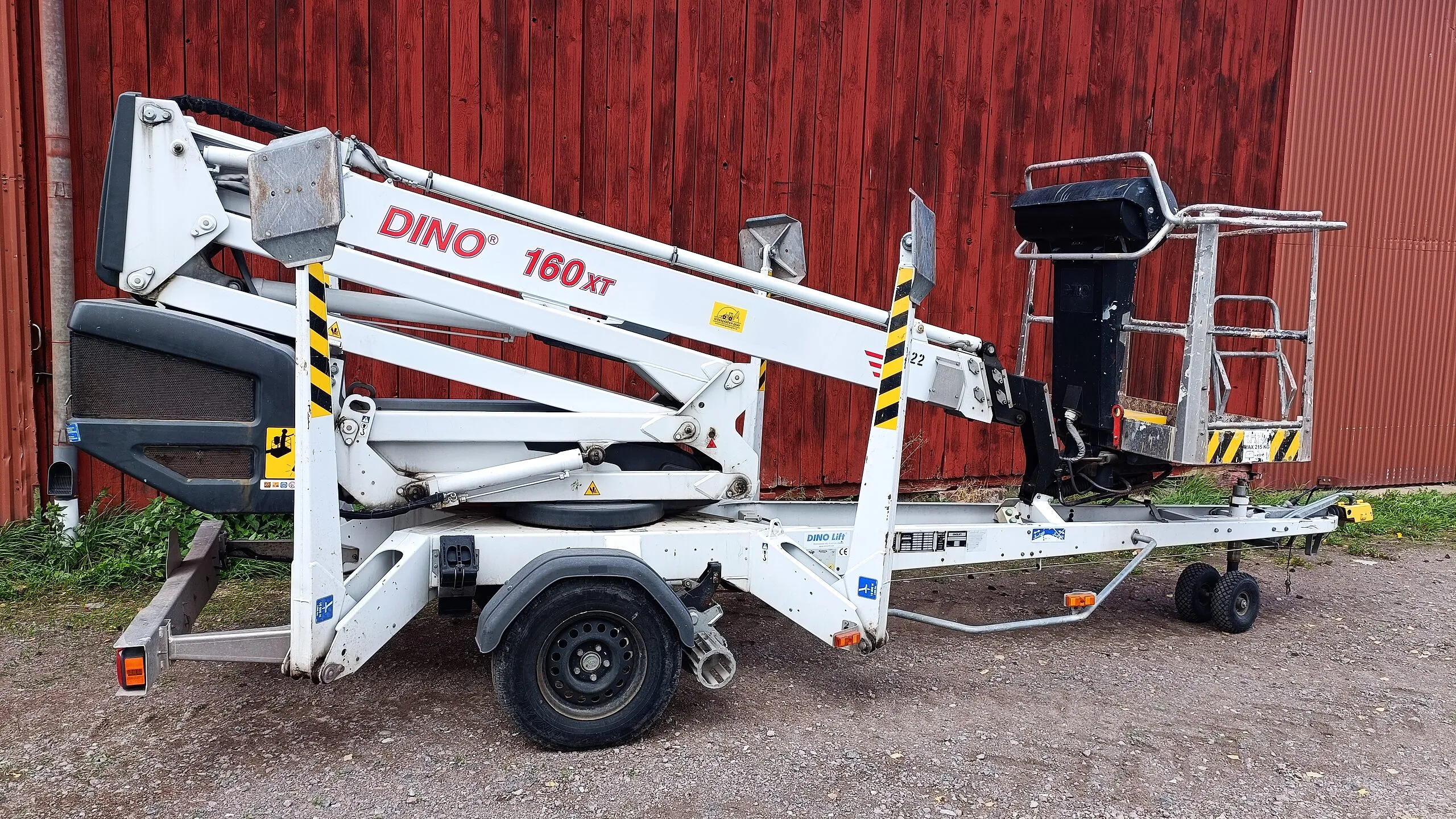 Släpvagnsburen skylift, Dino 160XT, parkerad framför en röd ladugårdsvägg